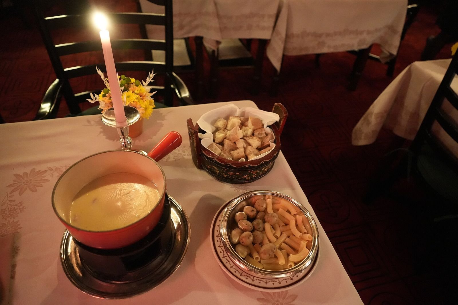 Panela de fondue de queijo com pães, prato típico dos restaurantes de Bariloche no inverno