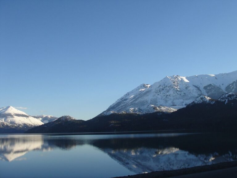 Montanhas nevadas refletidas no Lago Gutiérrez, em Bariloche
