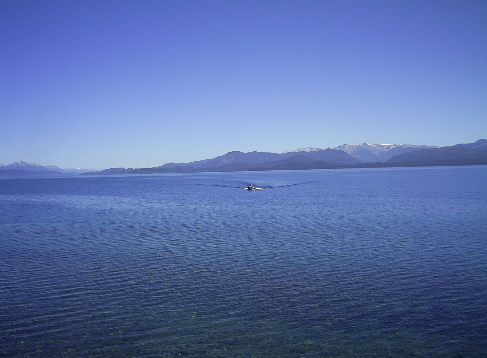 Quanto custa uma viagem para Bariloche: Lago Nahuel Huapi e montanhas em dia de sol
